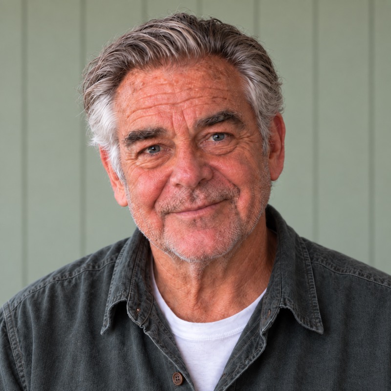 Harlan Fenton, a man in his late sixties in a work shirt, photographed in his kitchen.